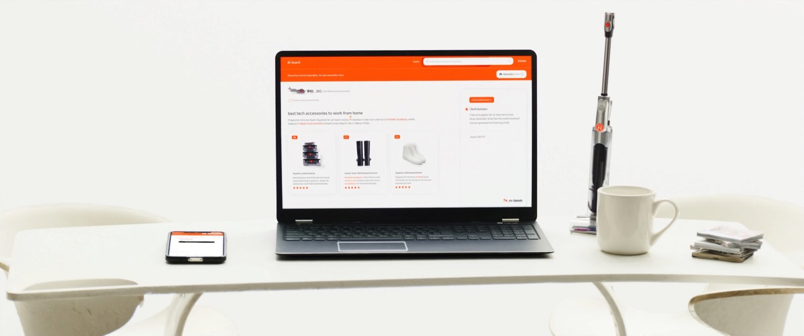 Laptop su una scrivania bianca e luminosa con una ricerca AI che consiglia tre prodotti, accanto smartphone, tazza e aspirapolvere senza filo